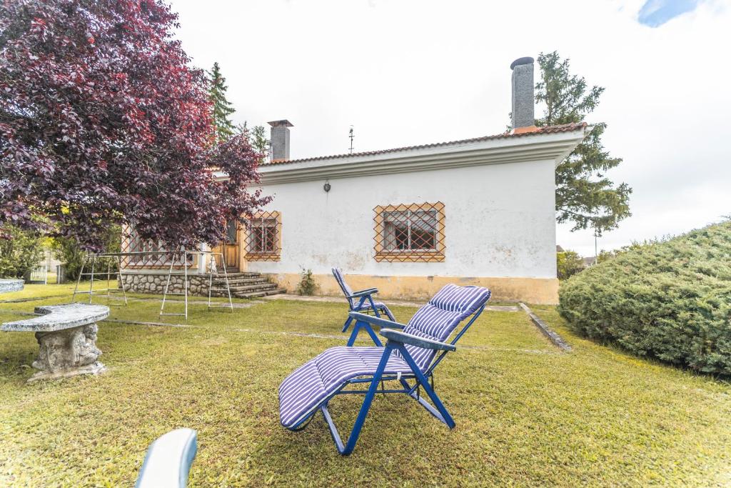 two blue chairs in the yard of a house at El chalet El uncar in Castrejón de la Peña