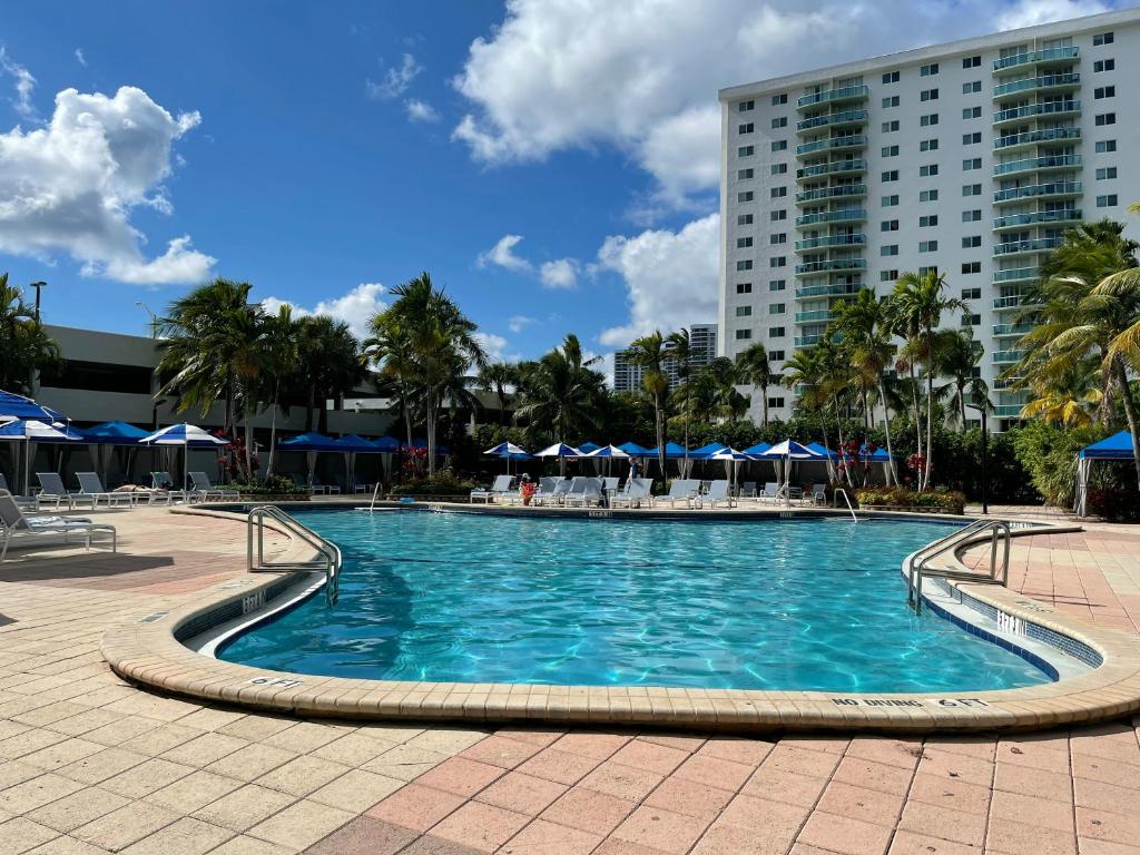 a swimming pool in front of a tall building at Apartments Miami in Sunny Isles Beach