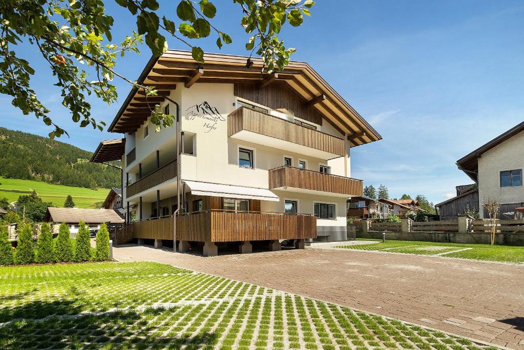 a building with a balcony on the side of it at Premium App Hofer Heidi in Villabassa