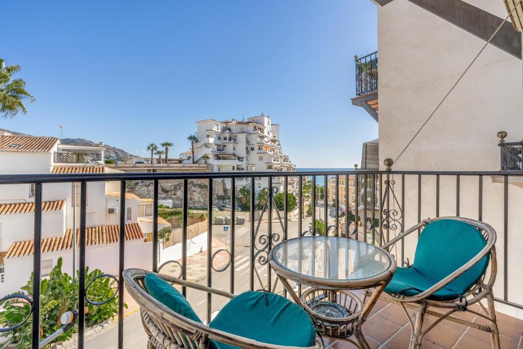 a balcony with two chairs and a glass table at El Tesorillo Andalúz in Almuñécar