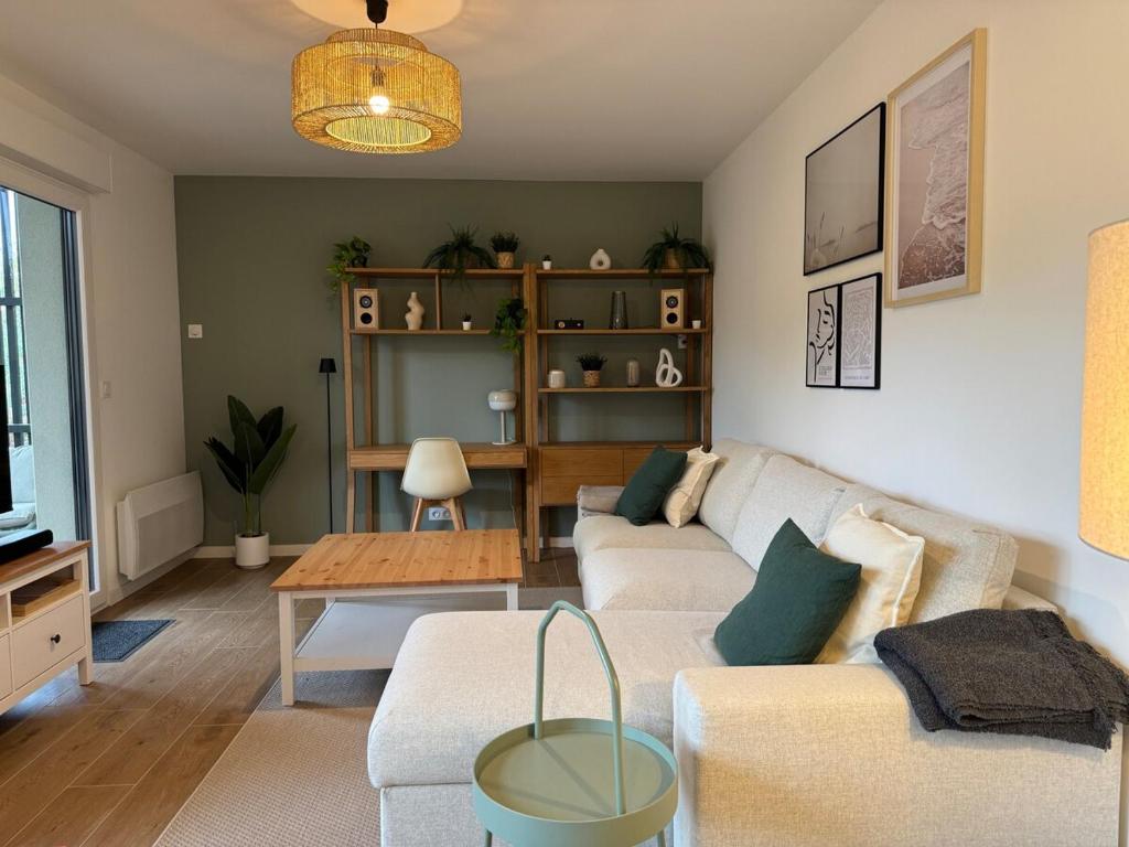 a living room with a couch and a table at Appartement Autza 6 voyageurs proche des plages in Moliets-et-Maa