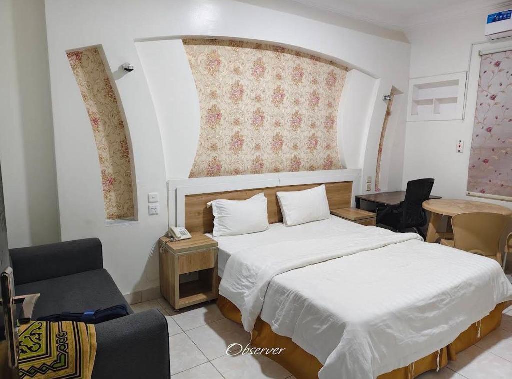 a bedroom with a white bed and a chair at شاطئ الحوية in Taif