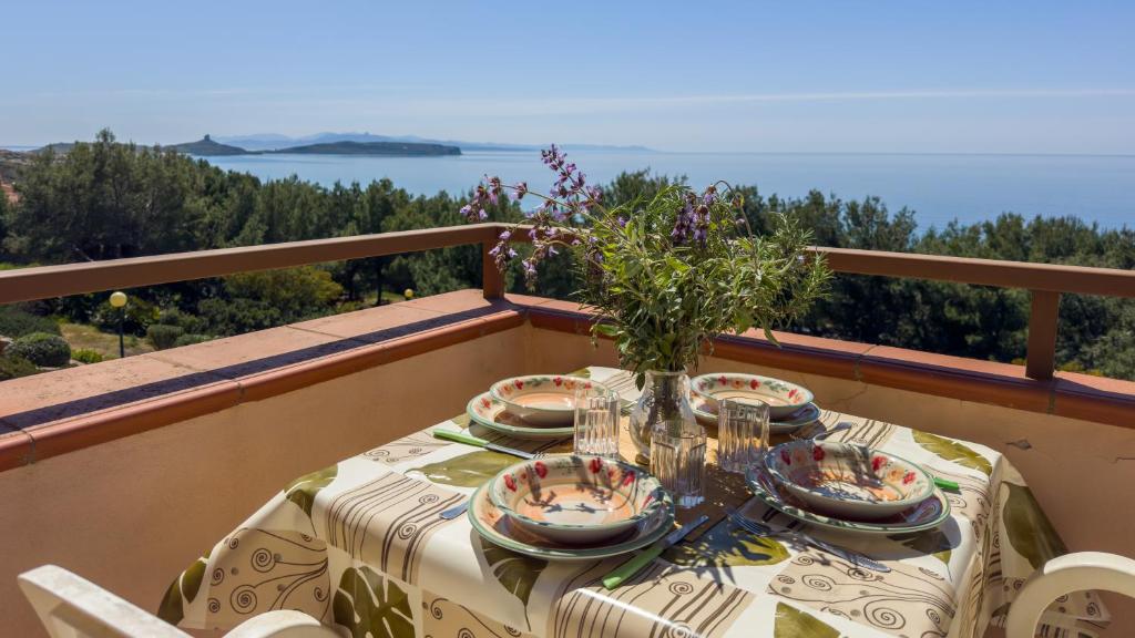 a table with a vase of flowers on a balcony at Blue Horizon Sinis in Funtana Meiga