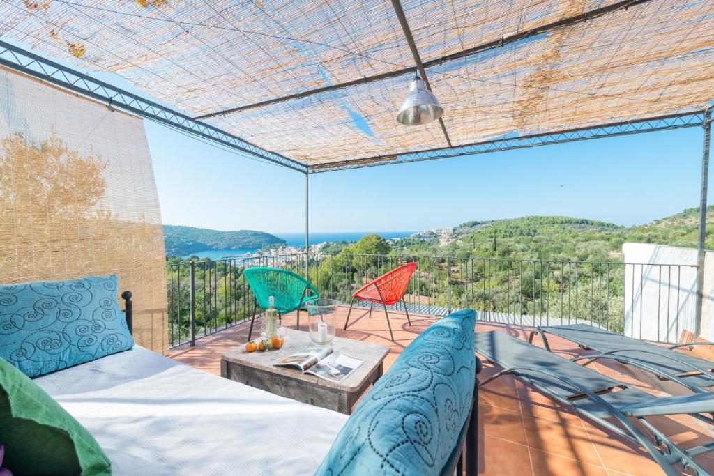 a room with a bed and chairs on a balcony at Can Divertit in Port de Soller