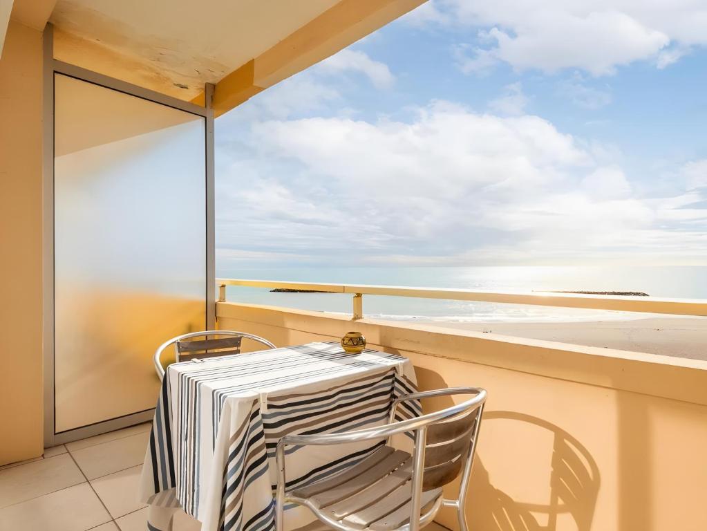 a table and chairs on a balcony with a view of the ocean at Maison de la plage in Valras-Plage