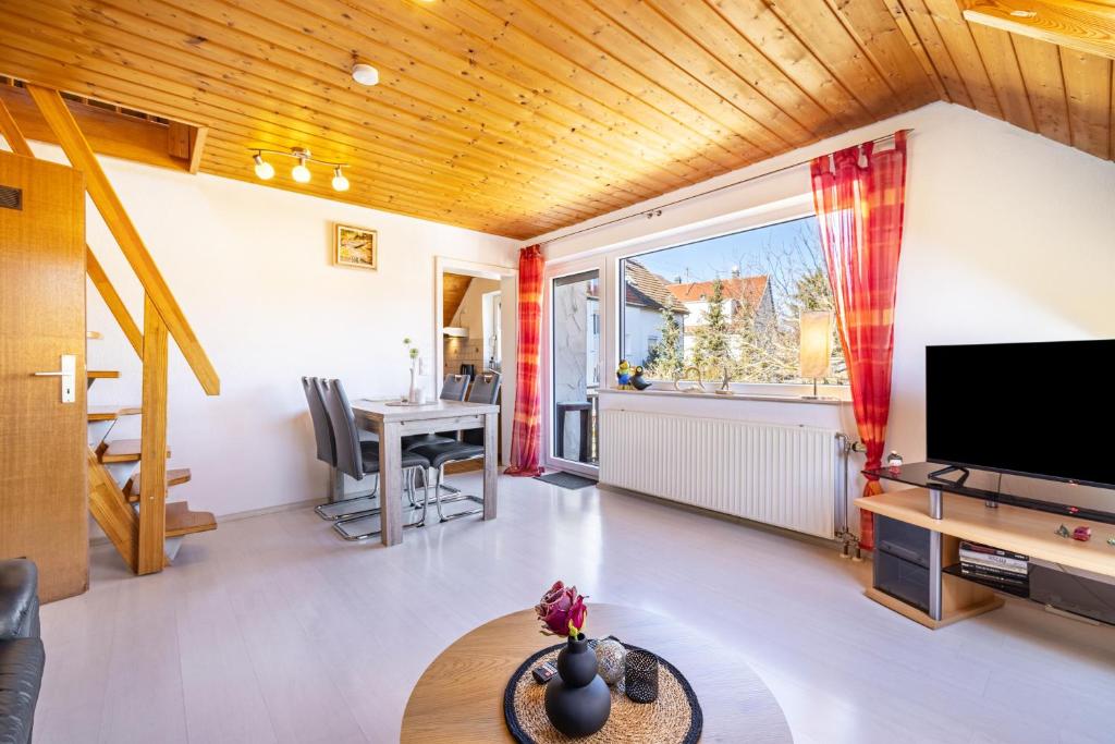 a living room with a television and a dining room at Ferienwohnung Sonnenblick in Albstadt