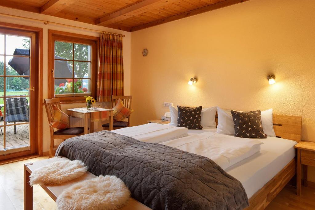 a bedroom with a bed and a table and a window at Hirschsprung in Breitnau
