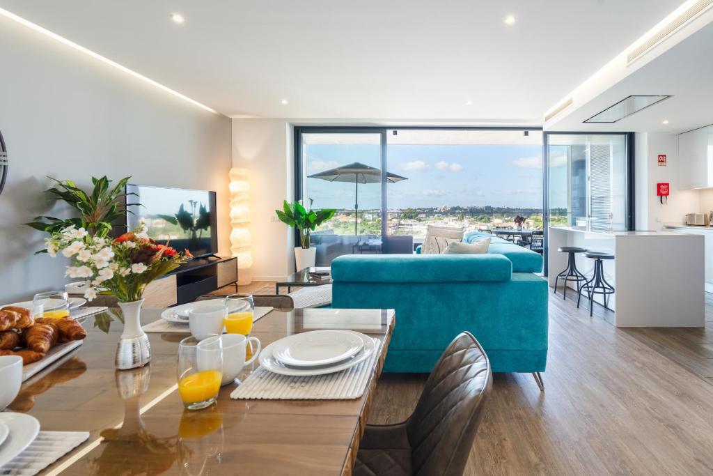 a living room with a table and a blue couch at Luxury T2 Apartment With Ocean View in Portimão