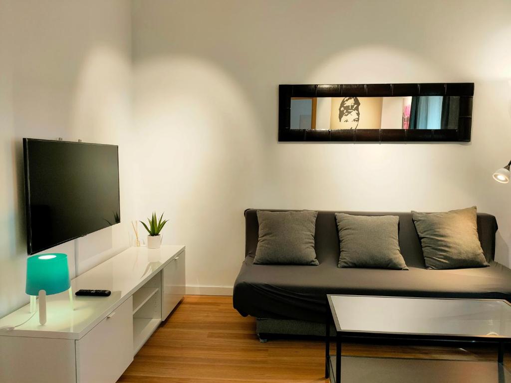 a living room with a couch and a flat screen tv at Erudito in Valencia