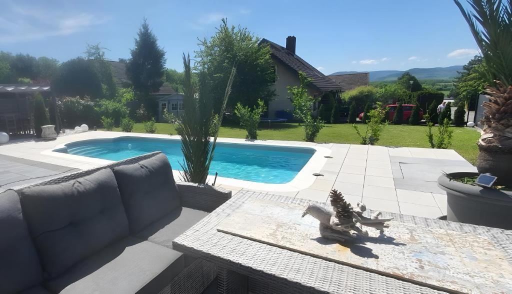 a swimming pool in a yard with a couch and a table at Fewo Harzblick Goslar mit Pool in Goslar