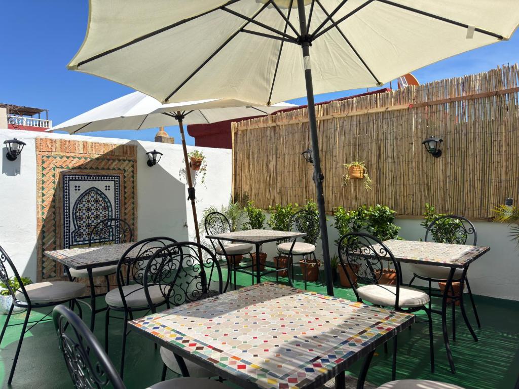 a patio with tables and chairs with an umbrella at Dar lalla Malika in Rabat