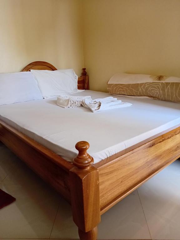 two beds with white sheets and towels on them at Kilimanjaro Budget in Moshi