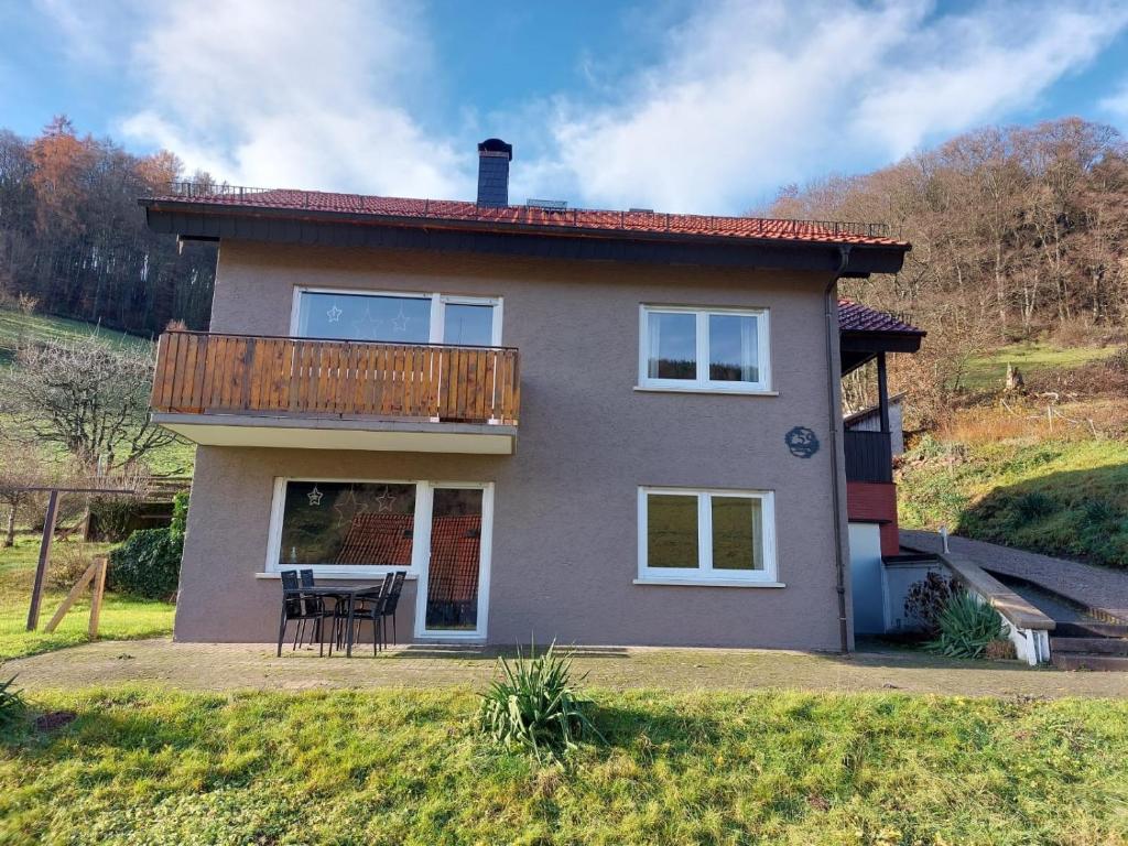 a house with a deck on the side of it at Ferienhaus Dorfidylle in Oberzent