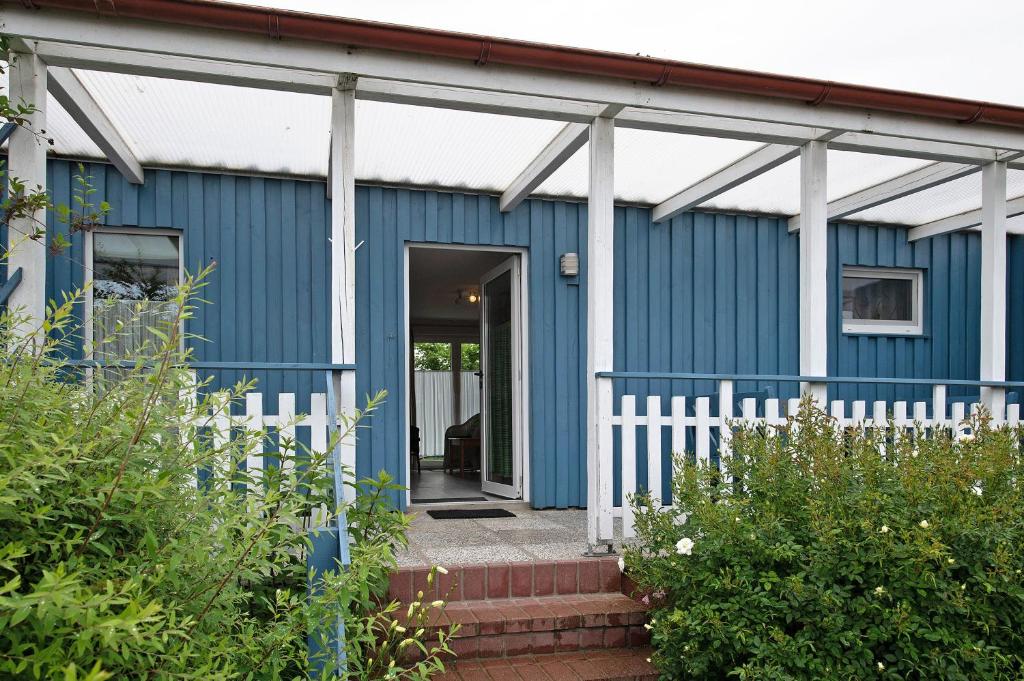 a blue house with a white fence in front of it at Möve Aba Bungalow 64 in Rerik