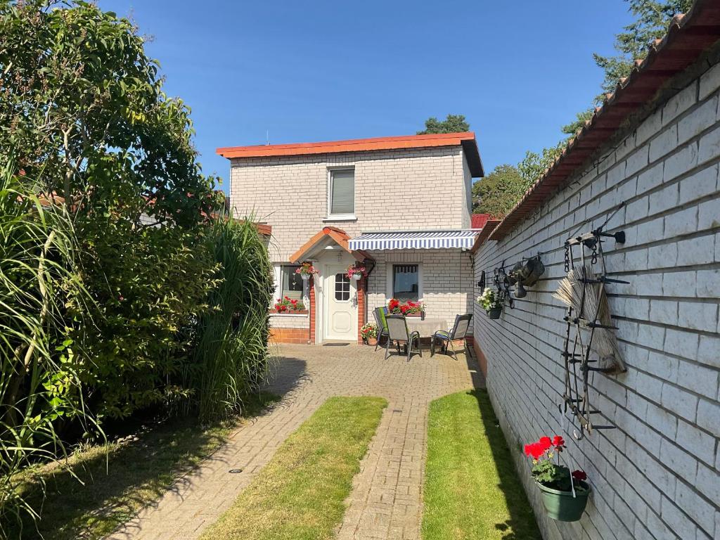 a white house with a brick wall and a patio at Ferienhaus Pahnke in Bergen auf Rügen