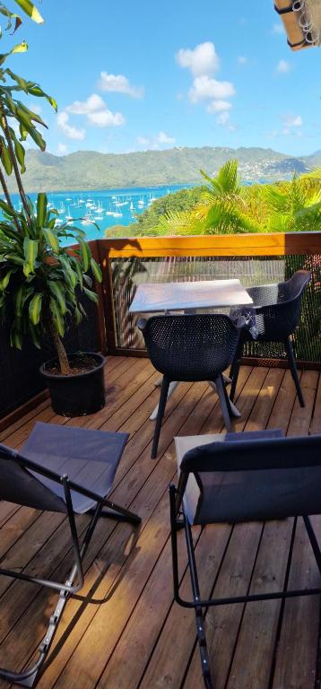 a patio with two chairs and a table on a deck at LA CAZ'ANOLI in Sainte-Anne