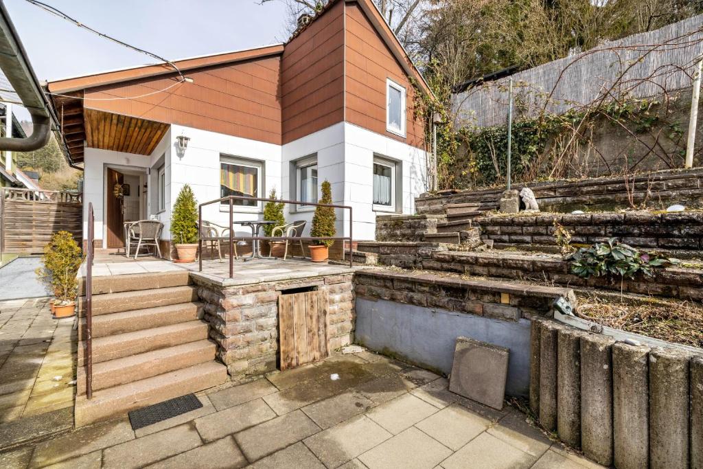 a small house with a wooden roof and a patio at Ferienwohnung Behrens-Reinke in Albstadt