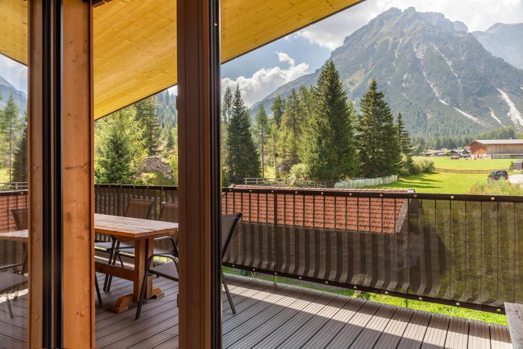a balcony with a table and a view of a mountain at Kwelle zur Natur Gamsberg in Obernberg am Brenner