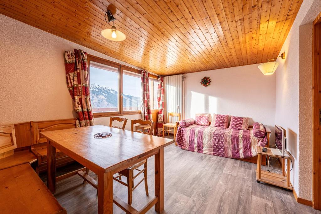 a living room with a bed and a table in a room at Appartement 22 - 5 personnes in Les Allues