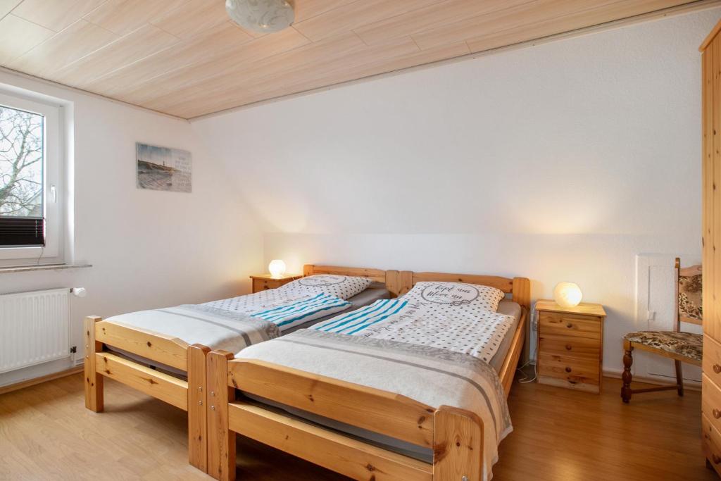 a bedroom with a wooden bed and a window at Ferienwohnung Horstmann in Meldorf