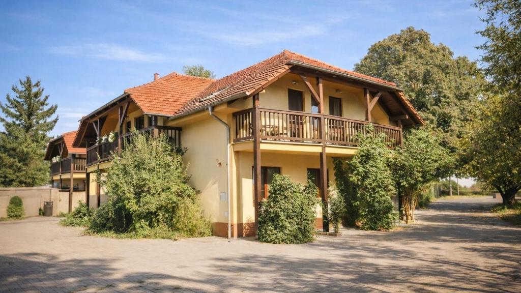 a large house with a balcony and trees at Ekofarma Sádky in Uherské Hradiště