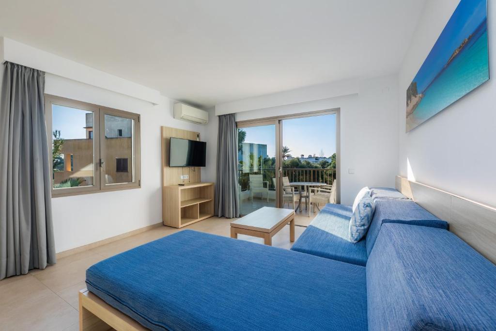 a hotel room with a blue bed and a balcony at Apartamento Aquamarina 7 in Cala Ferrera