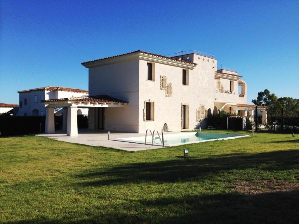 a large white house with a swimming pool in a yard at Villa Florida 2 with private pool in San Teodoro