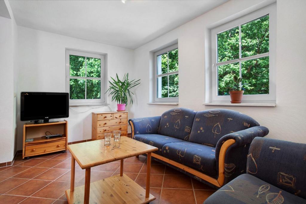 a living room with a blue couch and a tv at Haus Seeadler Wohnung 13 in Koserow