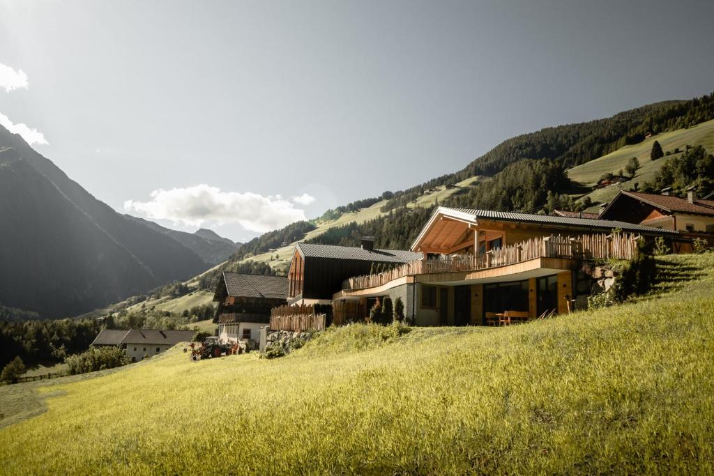 a group of buildings on a hill in a field at Chalet-Suite Wasser in Selva dei Molini