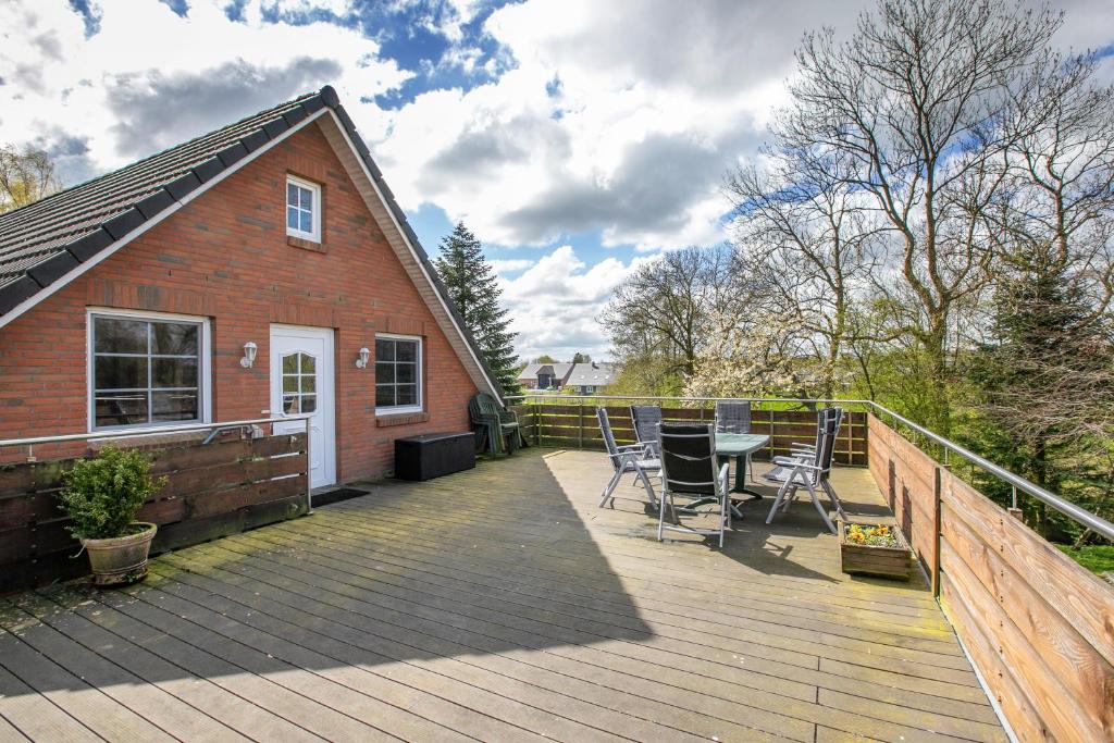 a wooden deck with a table and chairs on it at Ferienwohnung Nico in Langballig