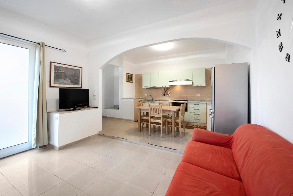 a living room with a red couch and a kitchen at Il Porto in Celle Ligure