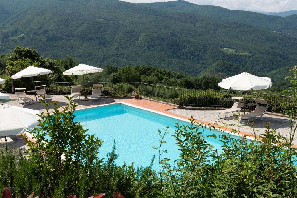 ein Schwimmbad mit Liegestühlen und Sonnenschirmen in der Unterkunft Universal Harmony - Balestruccio in Dicomano