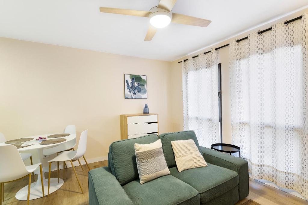 a living room with a green couch and a table at Apartamento Con Piscina Arinaga in Arinaga