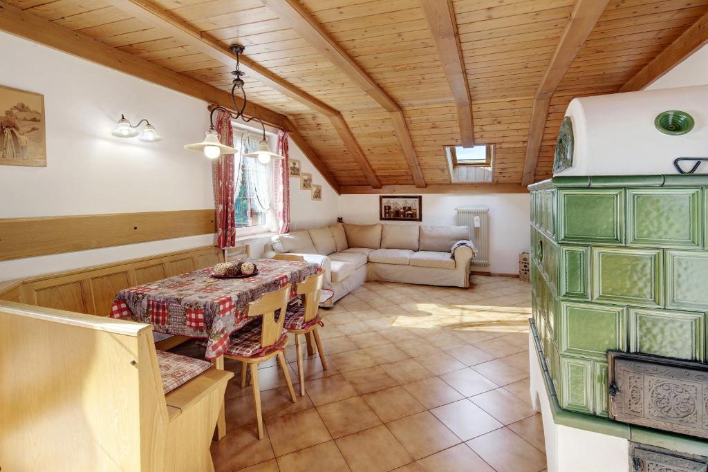 a living room with a table and a couch at Mansarda Maema in Moena