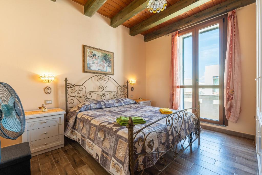 a bedroom with a bed and a large window at Da Giò, a due passi dal mare in Calasetta