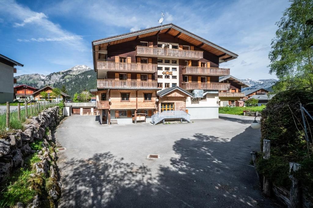 a large apartment building with a large parking lot at La Flèche d'Or in Châtel