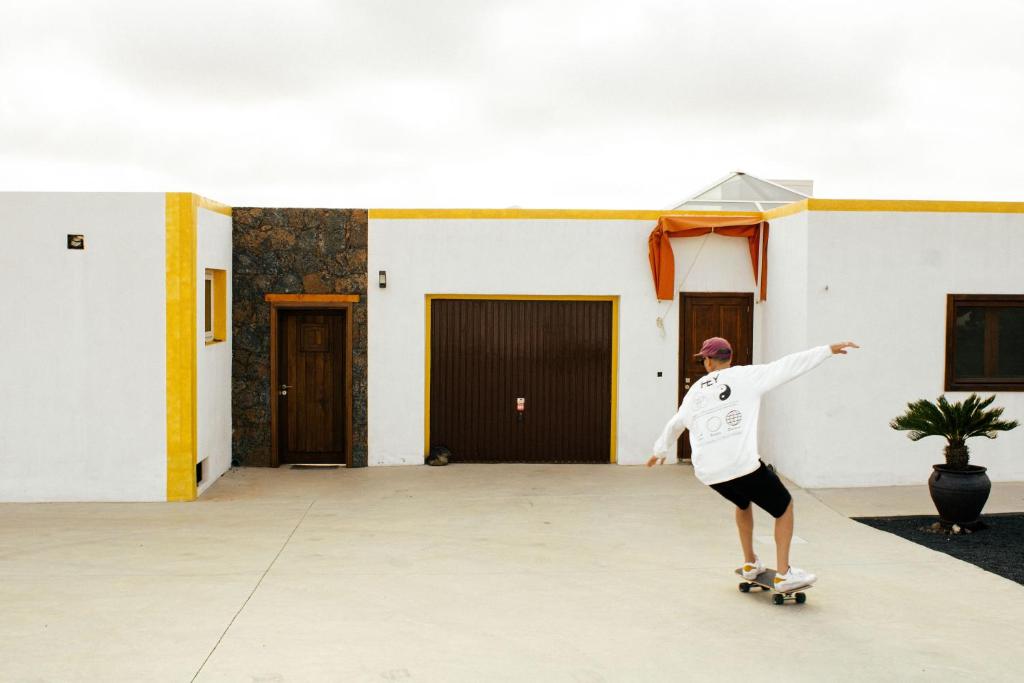 a man riding a skateboard in a parking lot at Casa Jenabe in La Vegueta