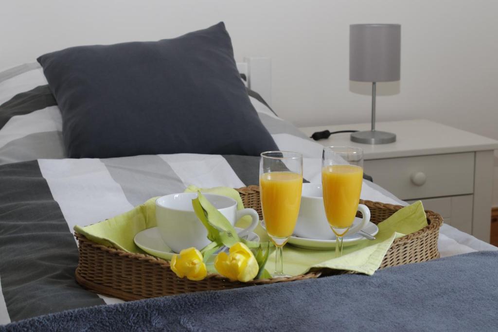 a basket of food and two glasses of orange juice at Sonnenhaus am See in Schwerin