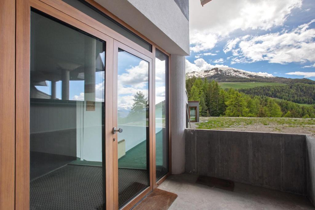 a balcony with glass doors and a view of a mountain at Appartamenti Larice Pila in Pila