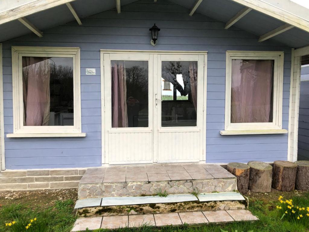a blue house with a white door and windows at Les Chalets de Babeth et Cathy in Trouan-le-Grand