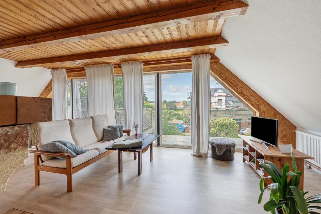 a living room with a couch and a tv at Fernblick in Behrensdorf