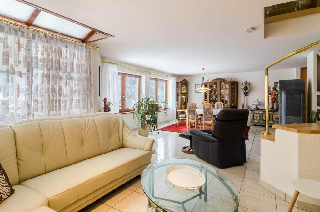 a living room with a couch and a glass table at Schwarzwalduhren Nescht Triberg in Triberg