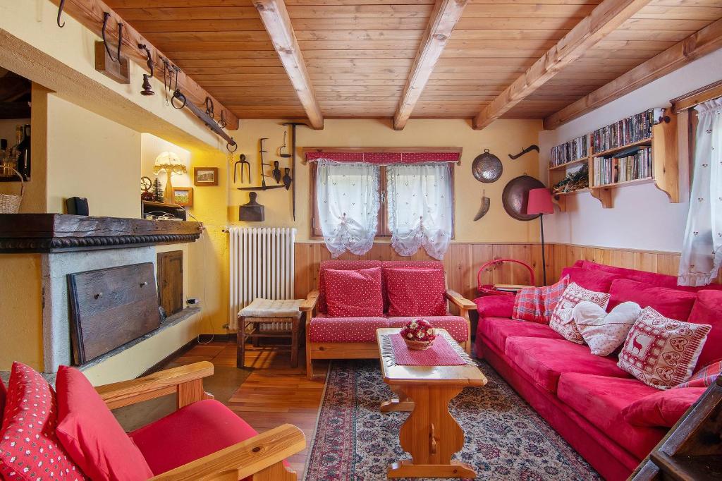 a living room with red couches and a tv at La Baita Verde in Motta