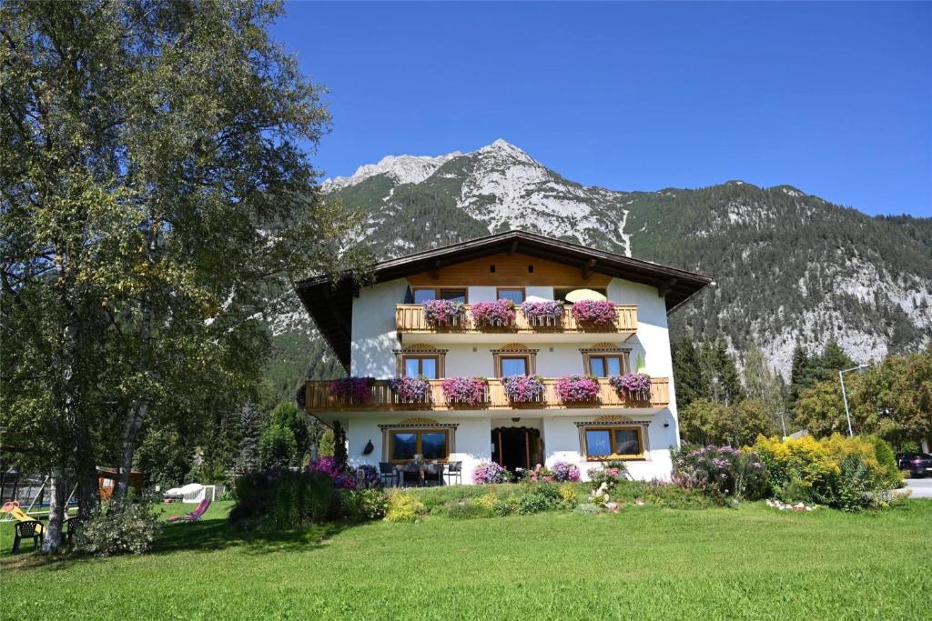 a building with flower boxes on it in front of a mountain at Birkenhof in Leutasch