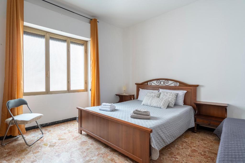 a bedroom with a bed and a chair and a window at Jerzu Centro 2 in Jerzu