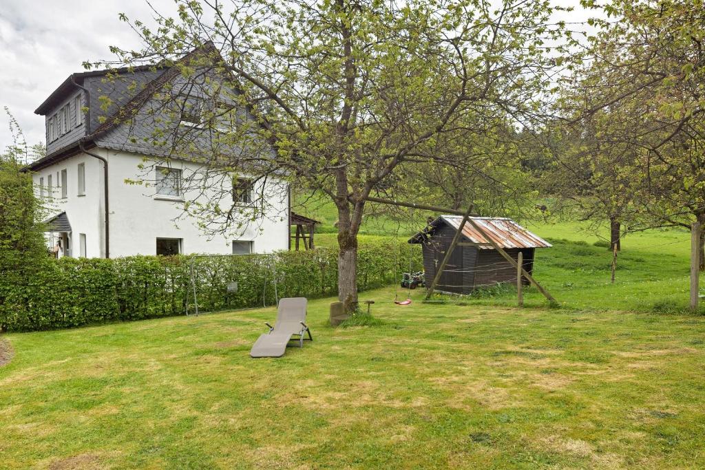 a white house with a bench in a yard at Ferienwohnung Peitz in Eslohe