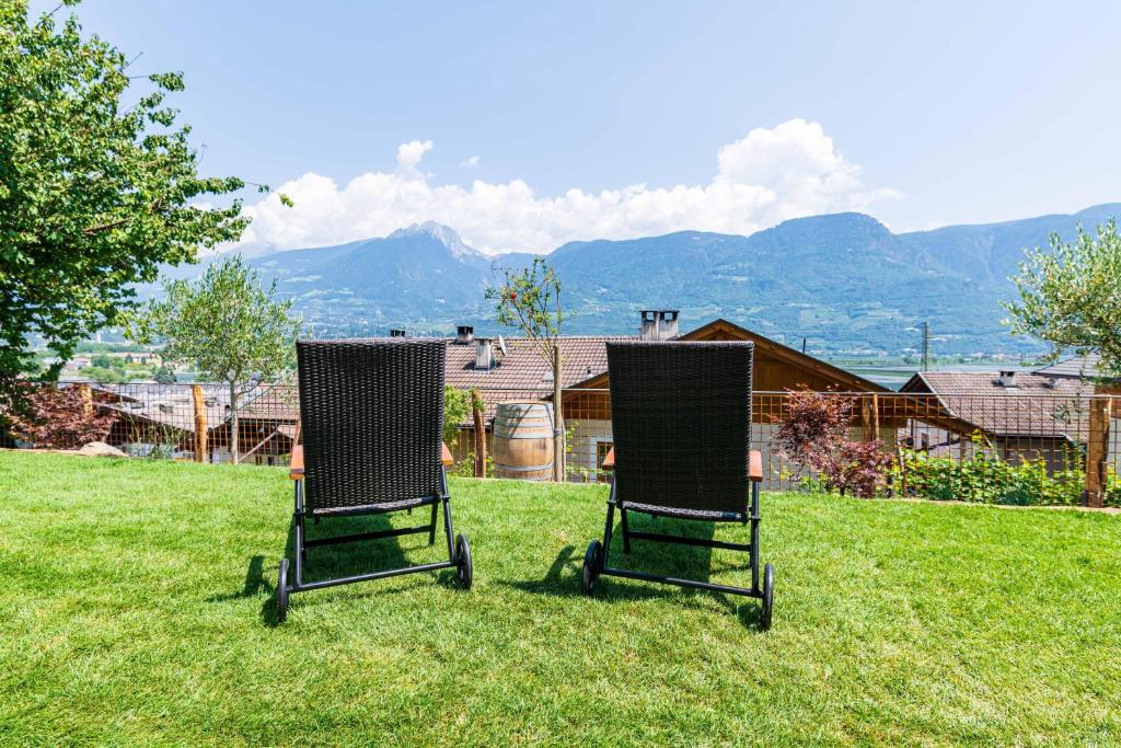two chairs sitting in the grass in a yard at Haus Nummer 9 in Marlengo