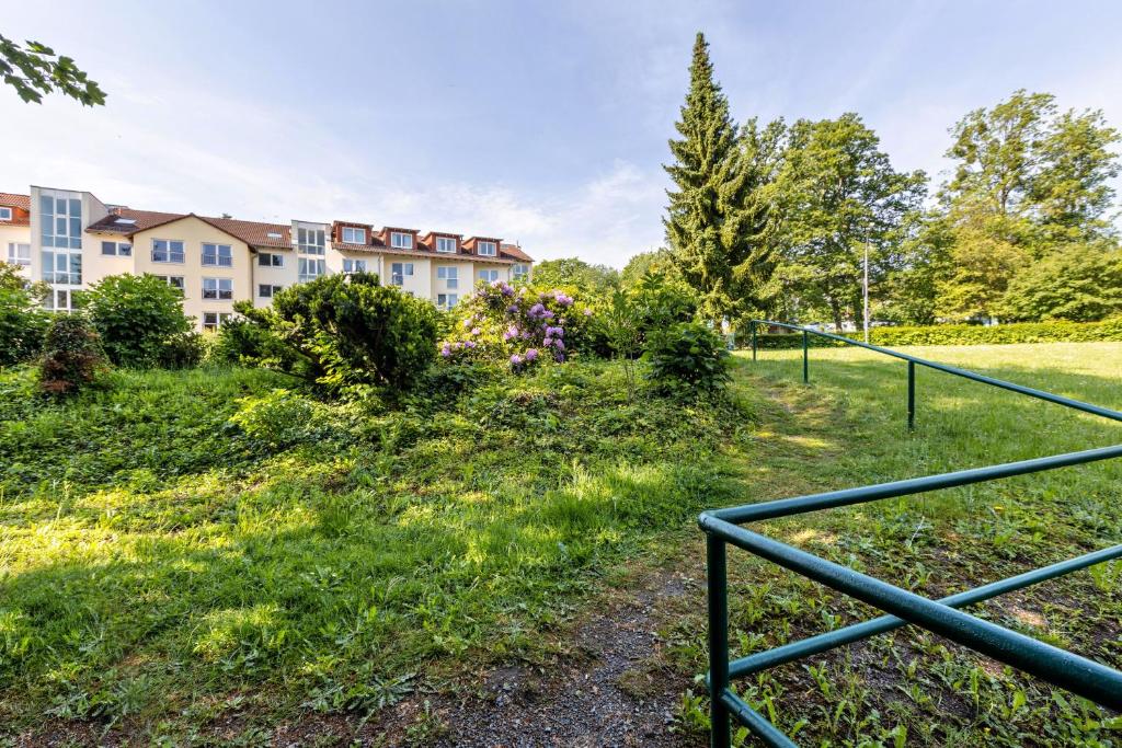 a view of a building with a fence at Aparthotel am Stadtpark in Bad Sachsa