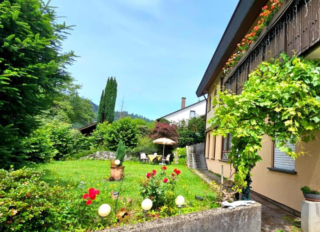 a garden with red flowers and a house at Ferienwohnung Wyss - Wolfach in Untertal