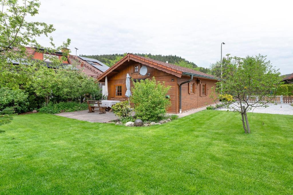 eine Blockhütte mit Garten und Picknicktisch in der Unterkunft Moi Holzhaisel in Elmstein